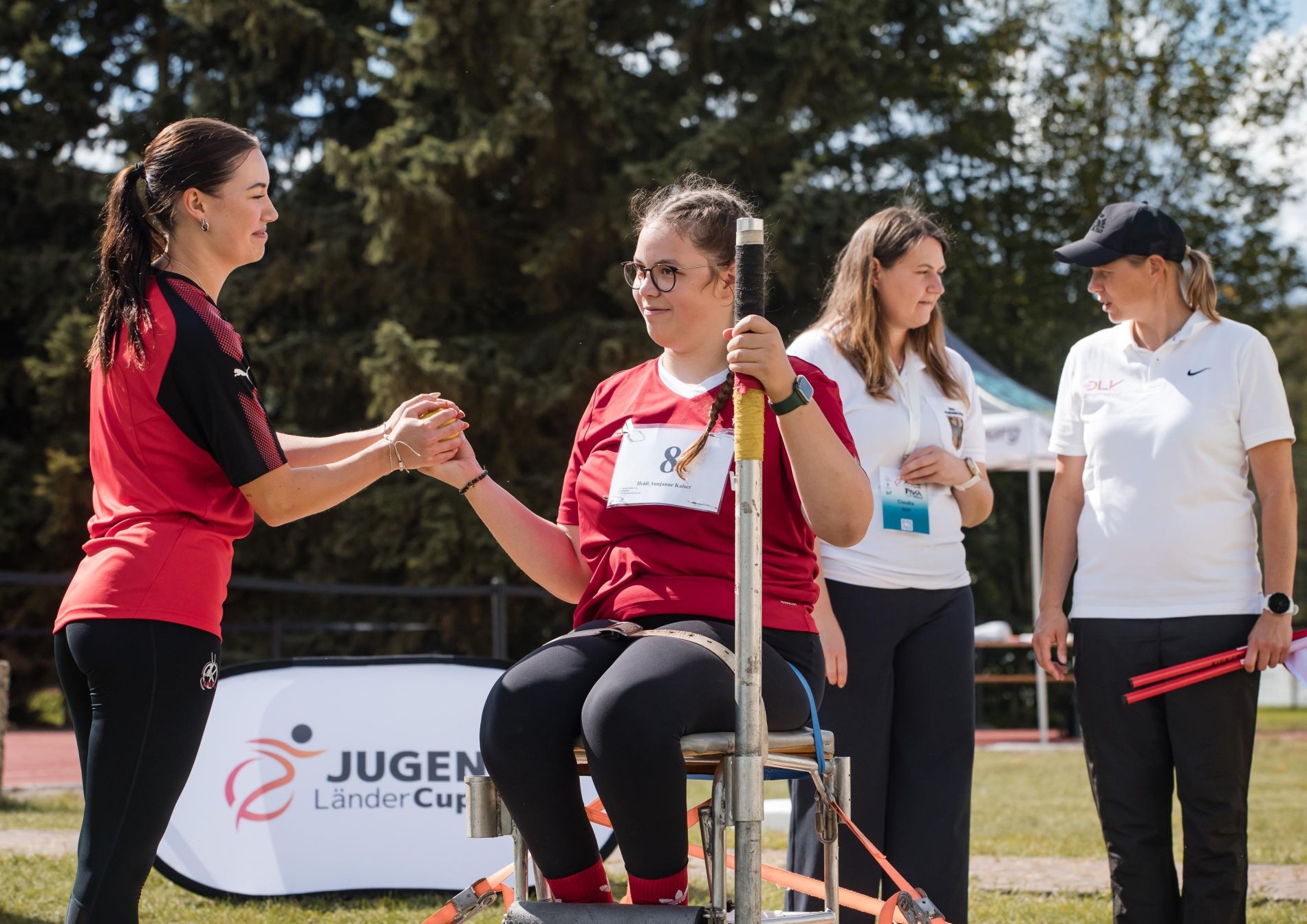 Sportlerinnen in weißen und roten Sportdress, die sich auf den Wettkampf vorbereiten