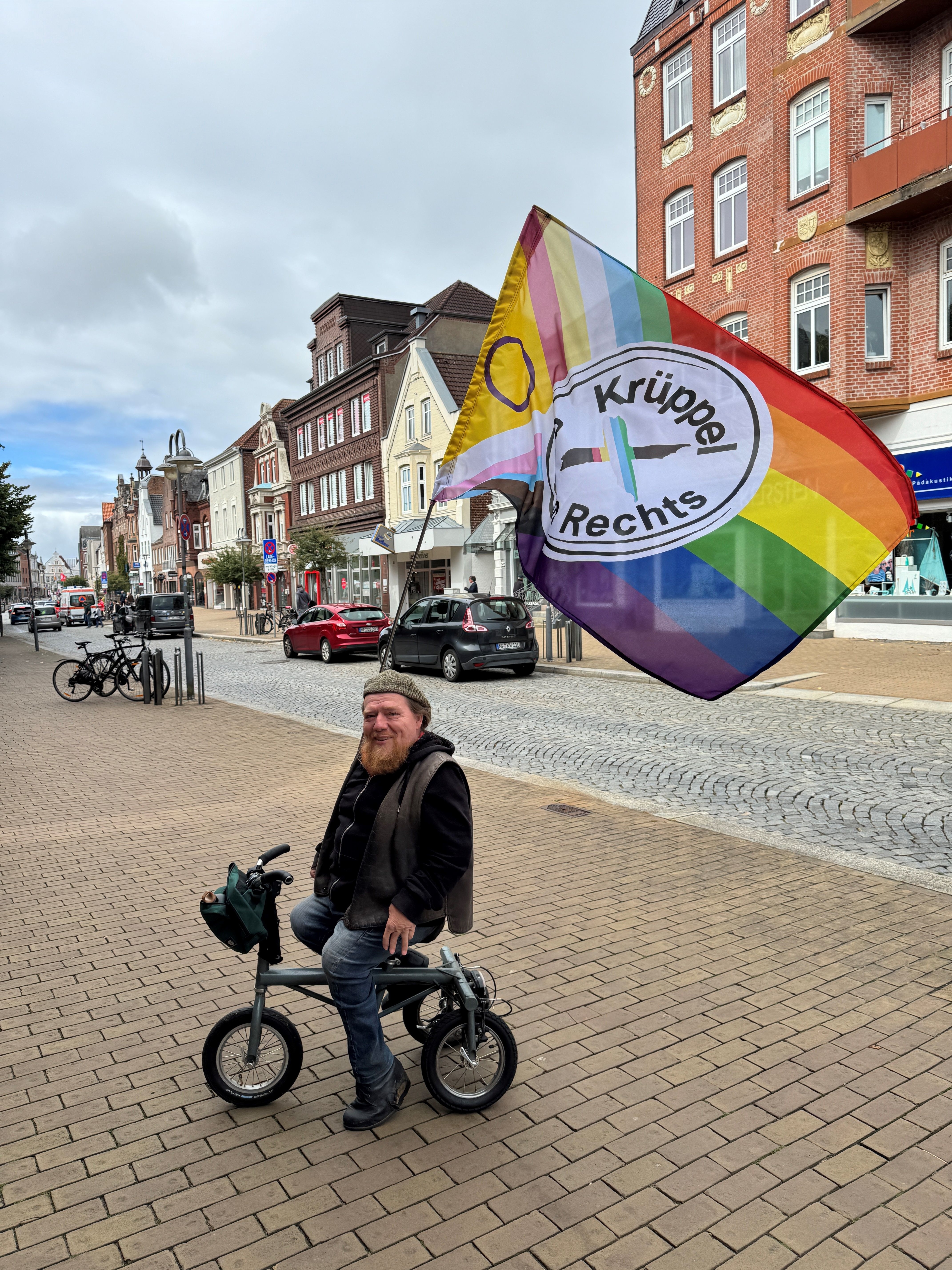 Christian Judith mit der Fahne von Krüppel gegen Rechts beim CSD am 23.8.2026 in Husum